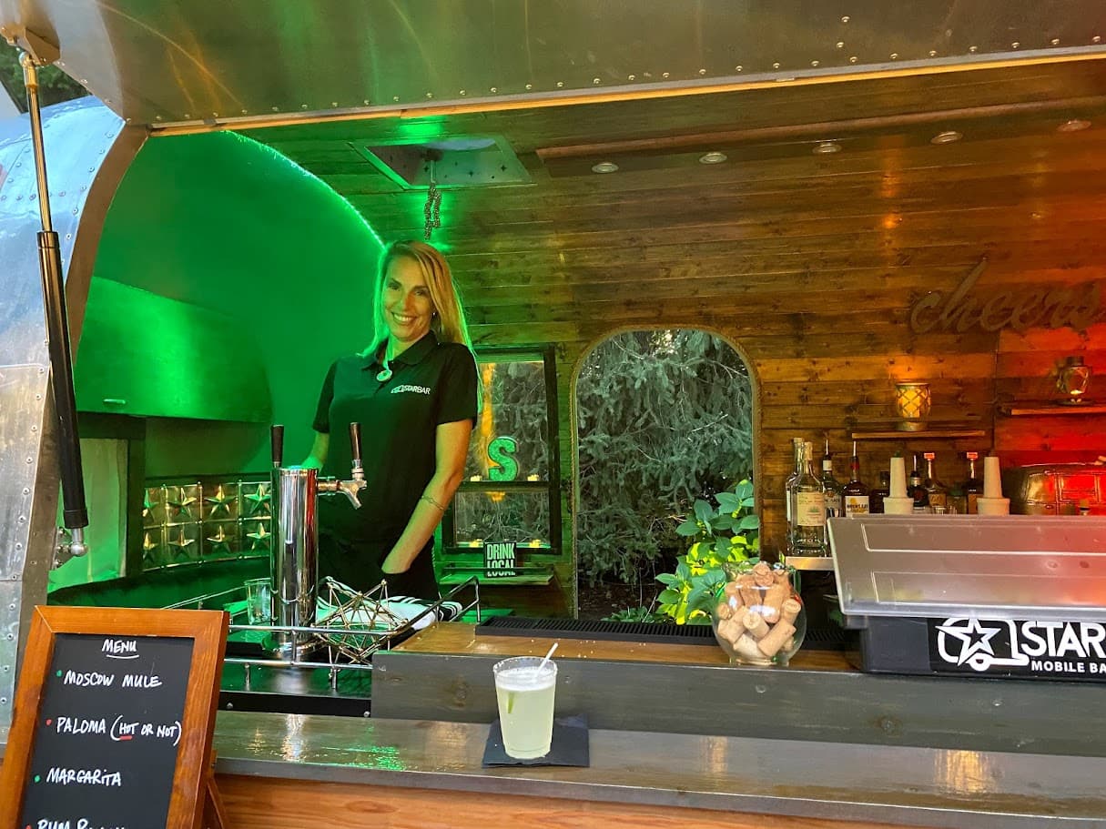 STARBAR NY bartender Jade pouring a drink behind the Airstream mobile bar