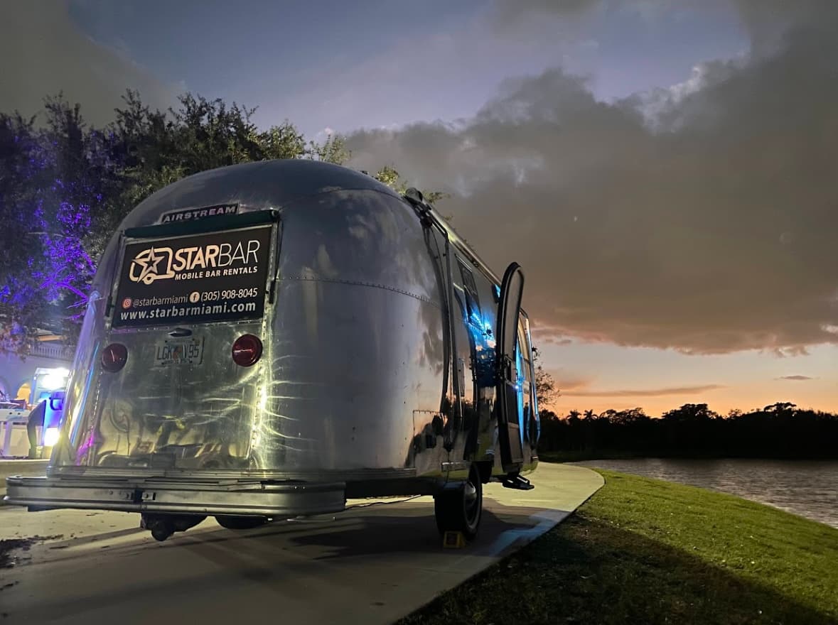 STARBAR Airstream mobile bar parked by the water at sunset